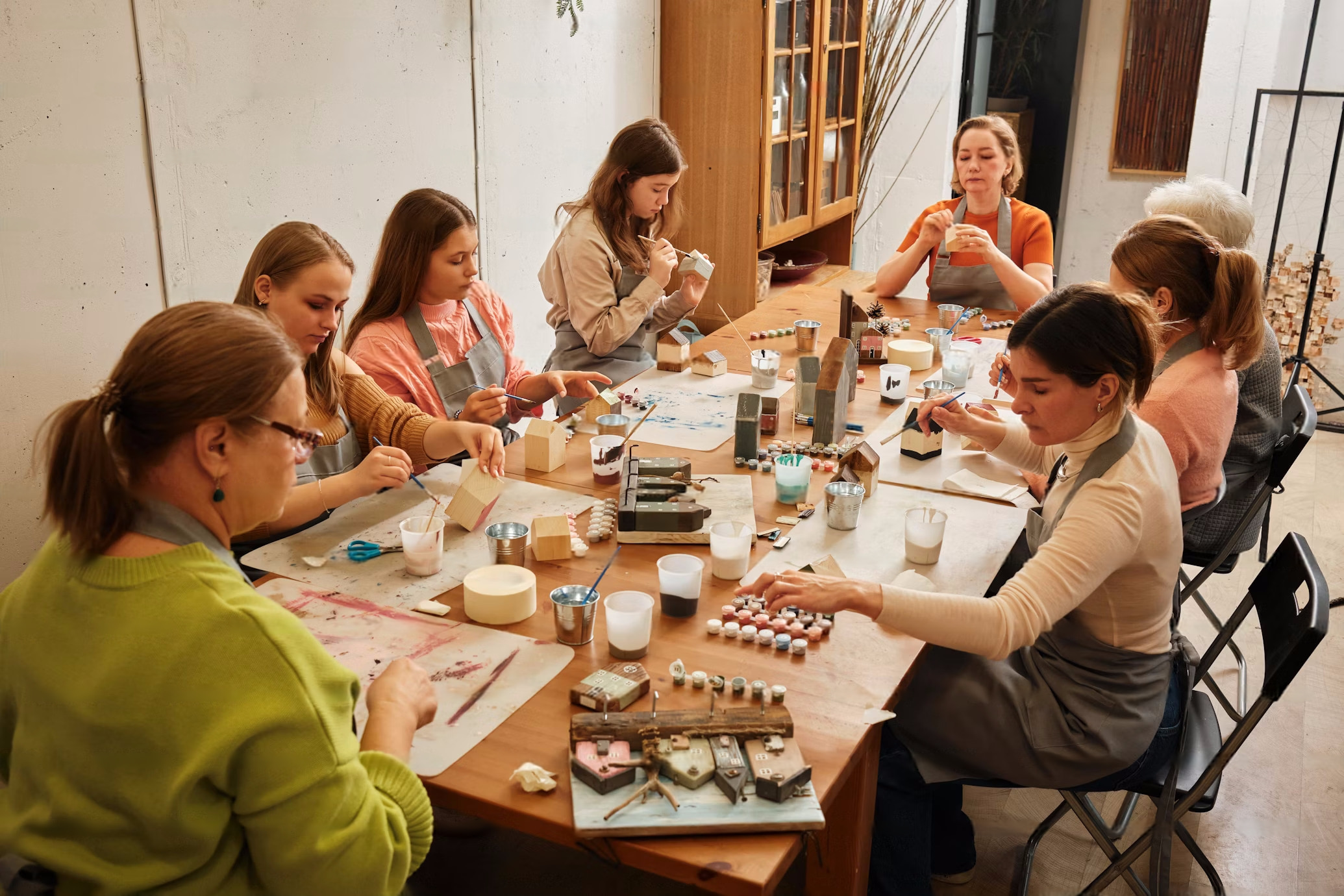 Group of women on a table creating art.